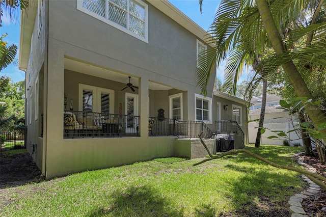 rear view of house with a lawn, ceiling fan, and covered porch