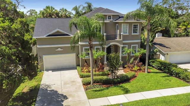 view of front facade with a garage, a balcony, and a front yard