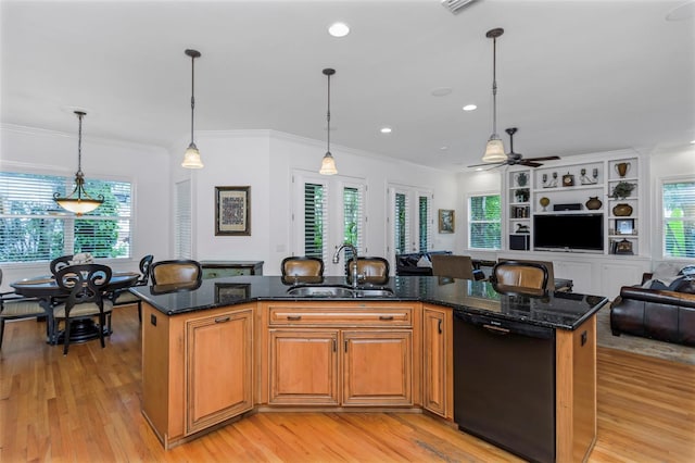 kitchen with pendant lighting, a center island with sink, sink, ceiling fan, and black dishwasher