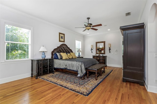 bedroom with hardwood / wood-style floors, ceiling fan, and ornamental molding