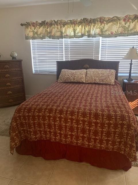 bedroom with multiple windows and tile patterned floors