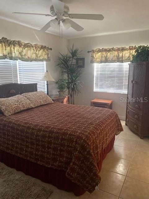 bedroom with ceiling fan and light tile patterned flooring