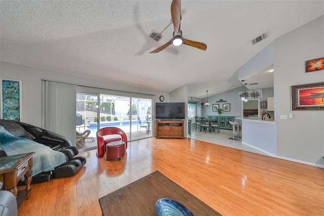 living room featuring a textured ceiling, ceiling fan, lofted ceiling, and hardwood / wood-style flooring