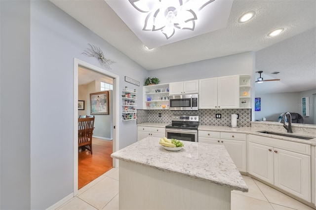 kitchen featuring a textured ceiling, white cabinets, sink, and appliances with stainless steel finishes