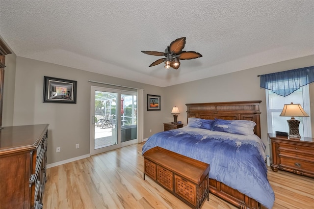 bedroom with access to outside, ceiling fan, light hardwood / wood-style flooring, and a textured ceiling