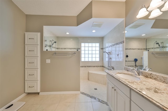 bathroom with a tile shower, tile patterned flooring, vanity, and a textured ceiling