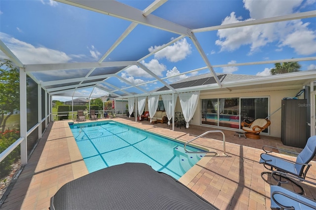 view of pool with glass enclosure and a patio area