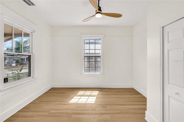 empty room featuring light hardwood / wood-style flooring, a wealth of natural light, and ceiling fan