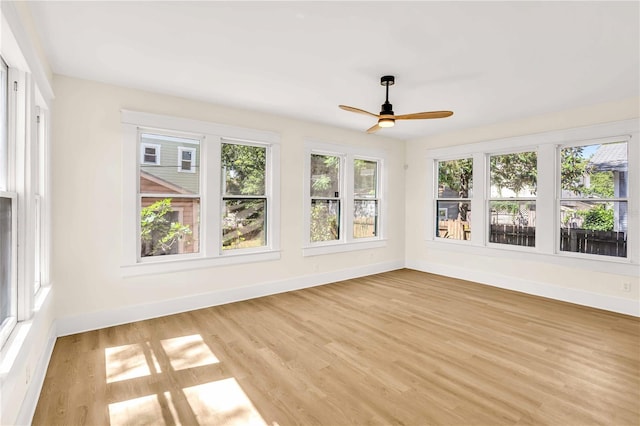 unfurnished sunroom with ceiling fan