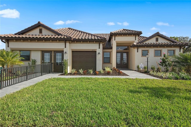 mediterranean / spanish-style home with a garage, a front yard, and french doors