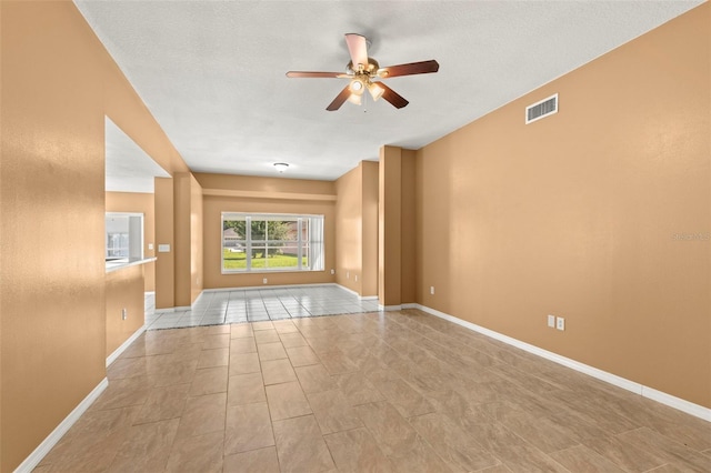 empty room featuring ceiling fan and a textured ceiling