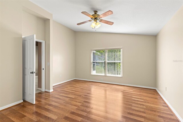 unfurnished room with lofted ceiling, ceiling fan, and light wood-type flooring