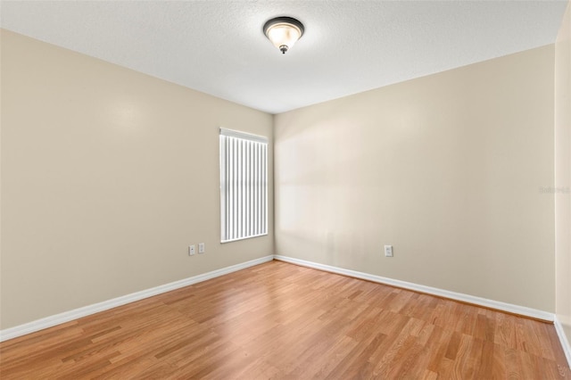 empty room featuring a textured ceiling and light wood-type flooring