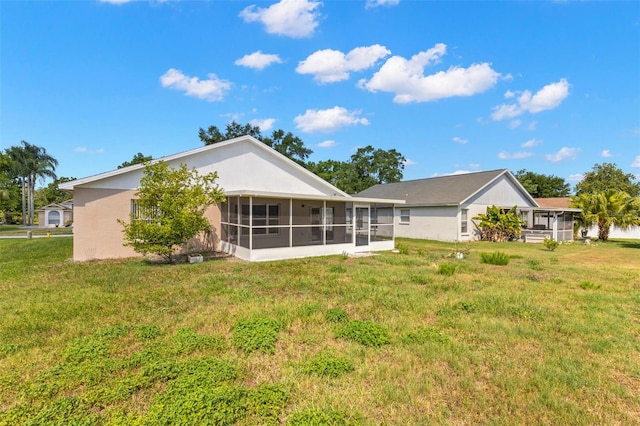 rear view of property featuring a yard and a sunroom