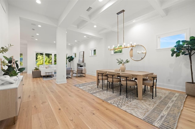 dining space featuring coffered ceiling, a chandelier, light hardwood / wood-style floors, and beam ceiling