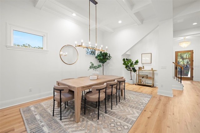 dining space featuring beam ceiling, coffered ceiling, and light wood-type flooring