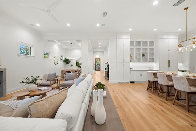 living room featuring ornamental molding and light wood-type flooring