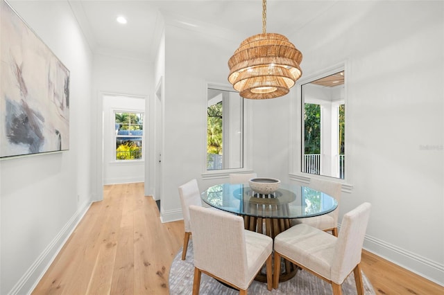 dining room featuring an inviting chandelier, crown molding, and light wood-type flooring