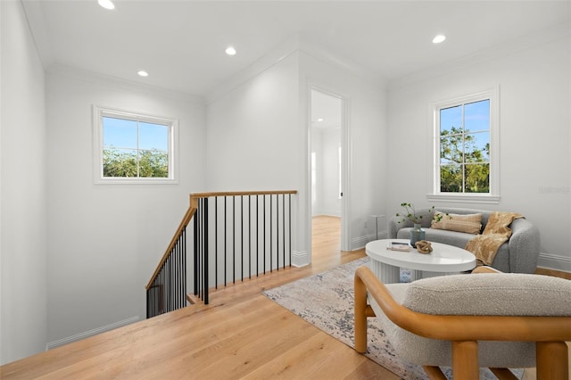 living area featuring hardwood / wood-style flooring and crown molding