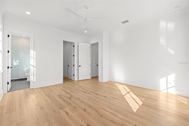 unfurnished bedroom featuring ceiling fan, connected bathroom, ornamental molding, a walk in closet, and light wood-type flooring