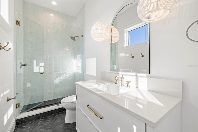 bathroom with vanity, a shower with shower door, and toilet