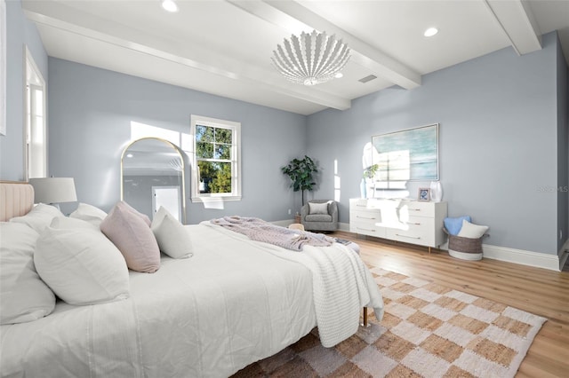 bedroom featuring hardwood / wood-style floors and beam ceiling