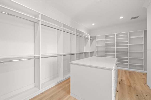 walk in closet with light hardwood / wood-style floors