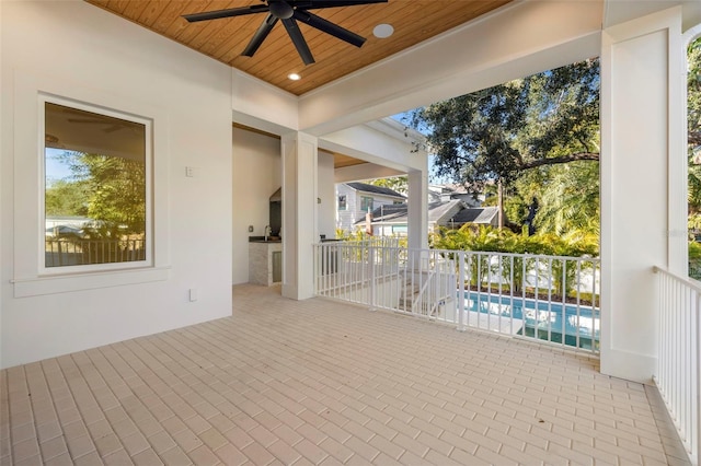 unfurnished sunroom with wooden ceiling and ceiling fan