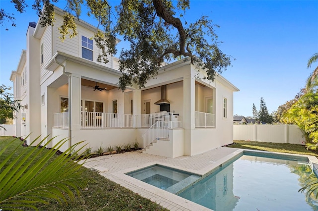 rear view of house featuring a swimming pool with hot tub and ceiling fan