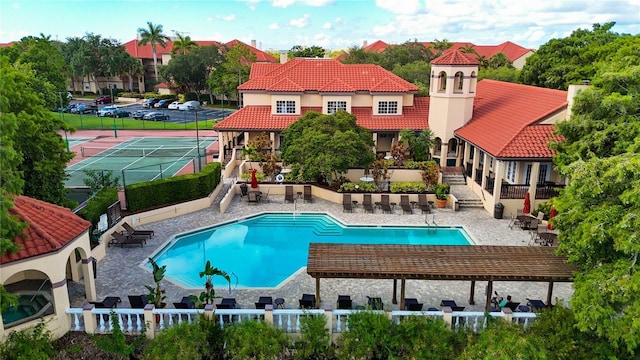 view of swimming pool featuring tennis court