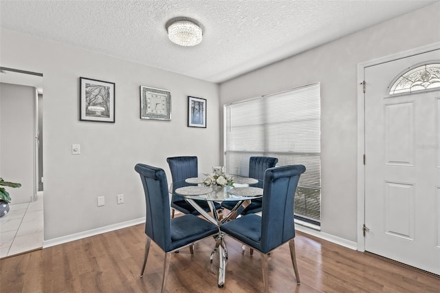 dining room with hardwood / wood-style floors and a textured ceiling