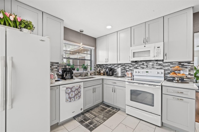 kitchen with decorative backsplash, sink, hanging light fixtures, and white appliances