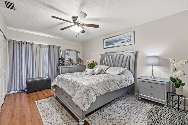 bedroom featuring a textured ceiling, dark hardwood / wood-style flooring, and ceiling fan