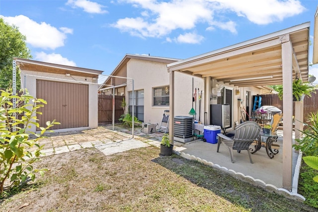 back of property featuring a shed and a patio area