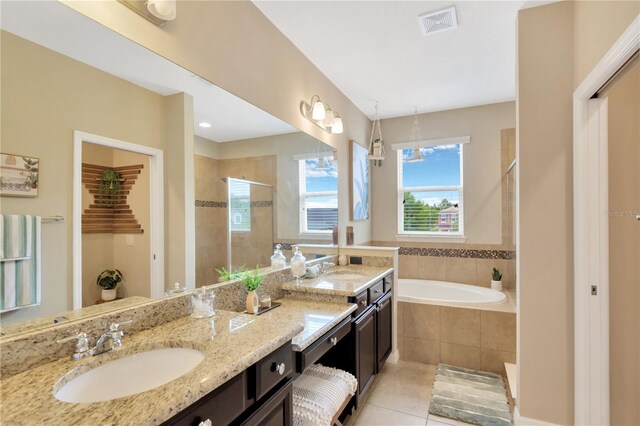 bathroom featuring tile patterned flooring, independent shower and bath, and vanity