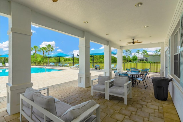 view of patio with a fenced in pool, outdoor lounge area, and ceiling fan