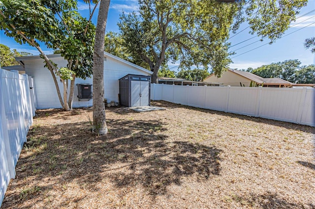 view of yard featuring a storage unit and central air condition unit