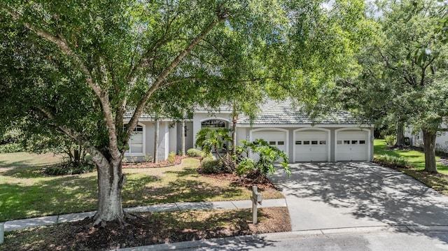 obstructed view of property featuring a front yard and a garage