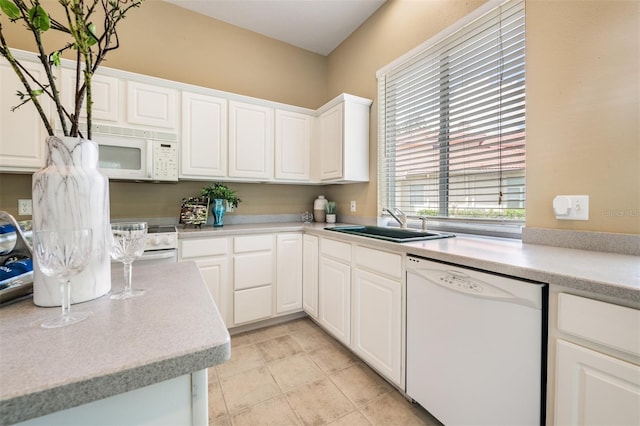 kitchen with sink, white cabinets, and white appliances