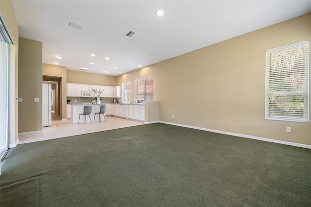 unfurnished living room with light colored carpet