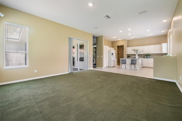 unfurnished living room with light colored carpet