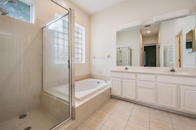 bathroom featuring tile patterned flooring, vanity, and shower with separate bathtub