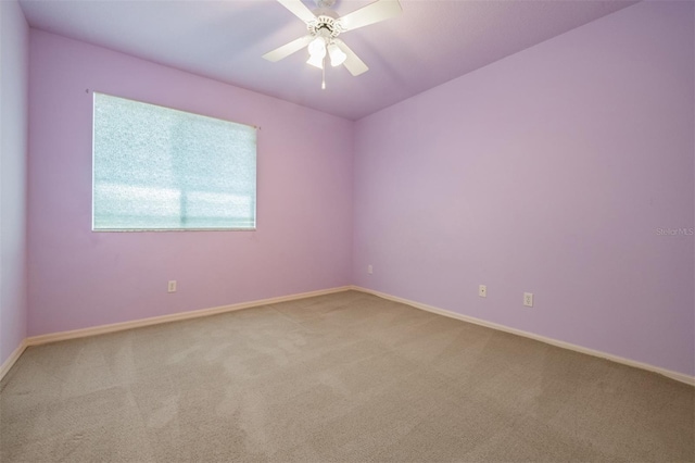 carpeted spare room featuring ceiling fan