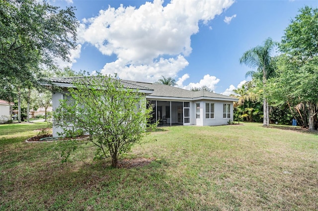 back of property featuring a sunroom and a yard