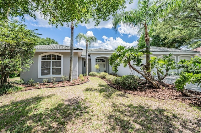 mediterranean / spanish-style home with a front yard and a garage