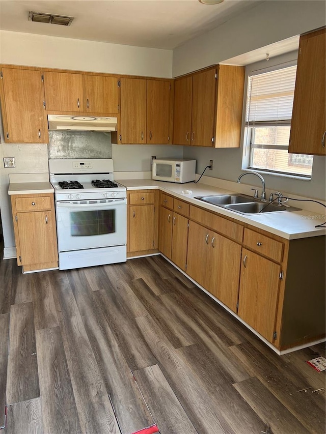 kitchen featuring sink, dark hardwood / wood-style floors, and white appliances