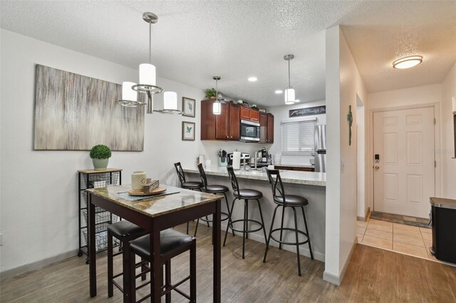 dining room with a textured ceiling and light wood-type flooring