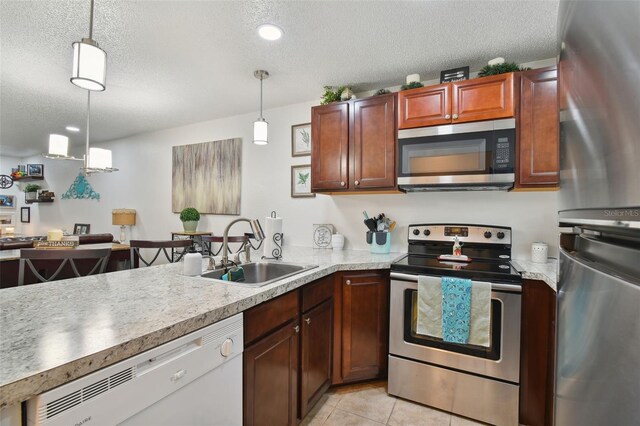 kitchen with appliances with stainless steel finishes, a textured ceiling, hanging light fixtures, and sink