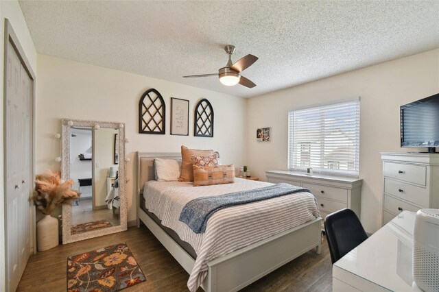 bedroom with dark hardwood / wood-style flooring, ceiling fan, a closet, and a textured ceiling