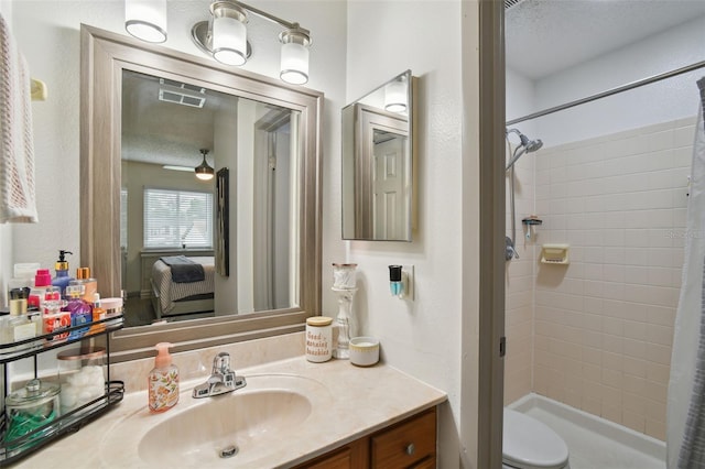 bathroom featuring a shower with curtain, vanity, toilet, and ceiling fan